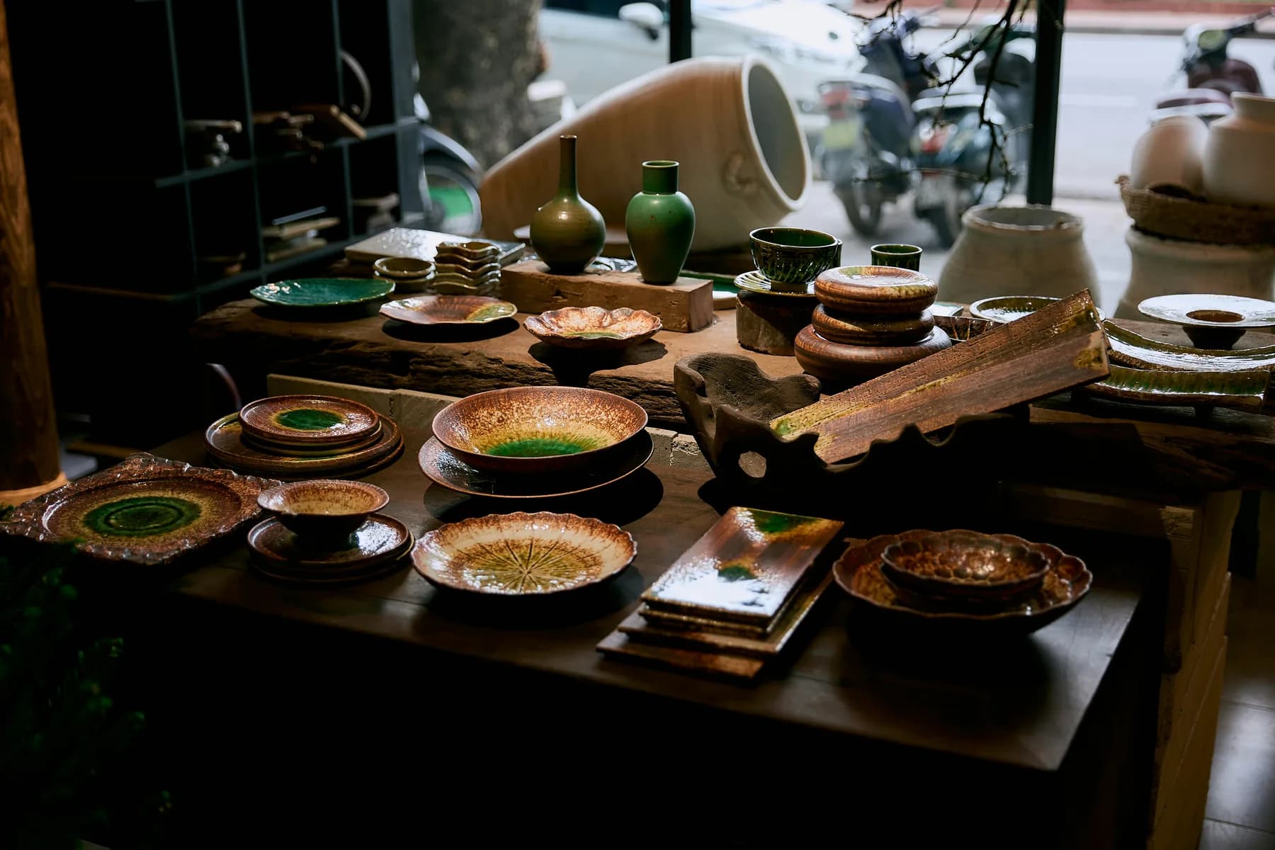 Arts de la table artisanaux disposés sur une table en bois