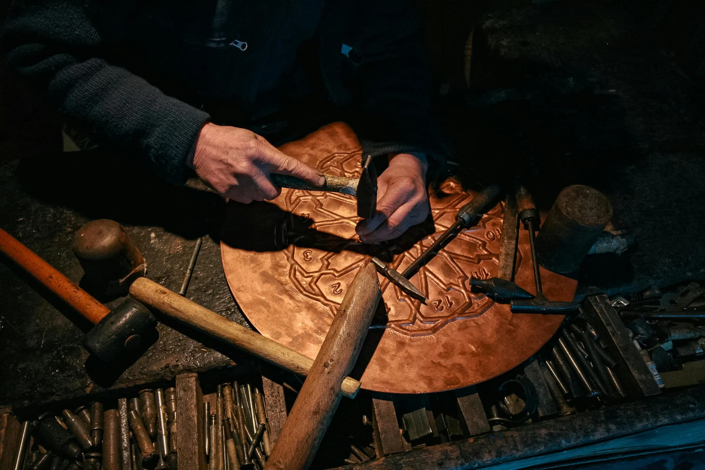 Artisan travaillant une pièce de cuivre dans un atelier de savoir-faire